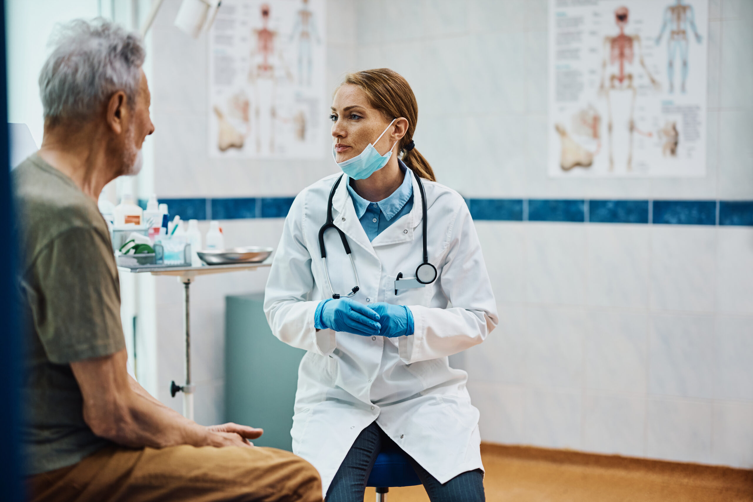 Doctor talking to her senior patient during medical examination at the clinic.