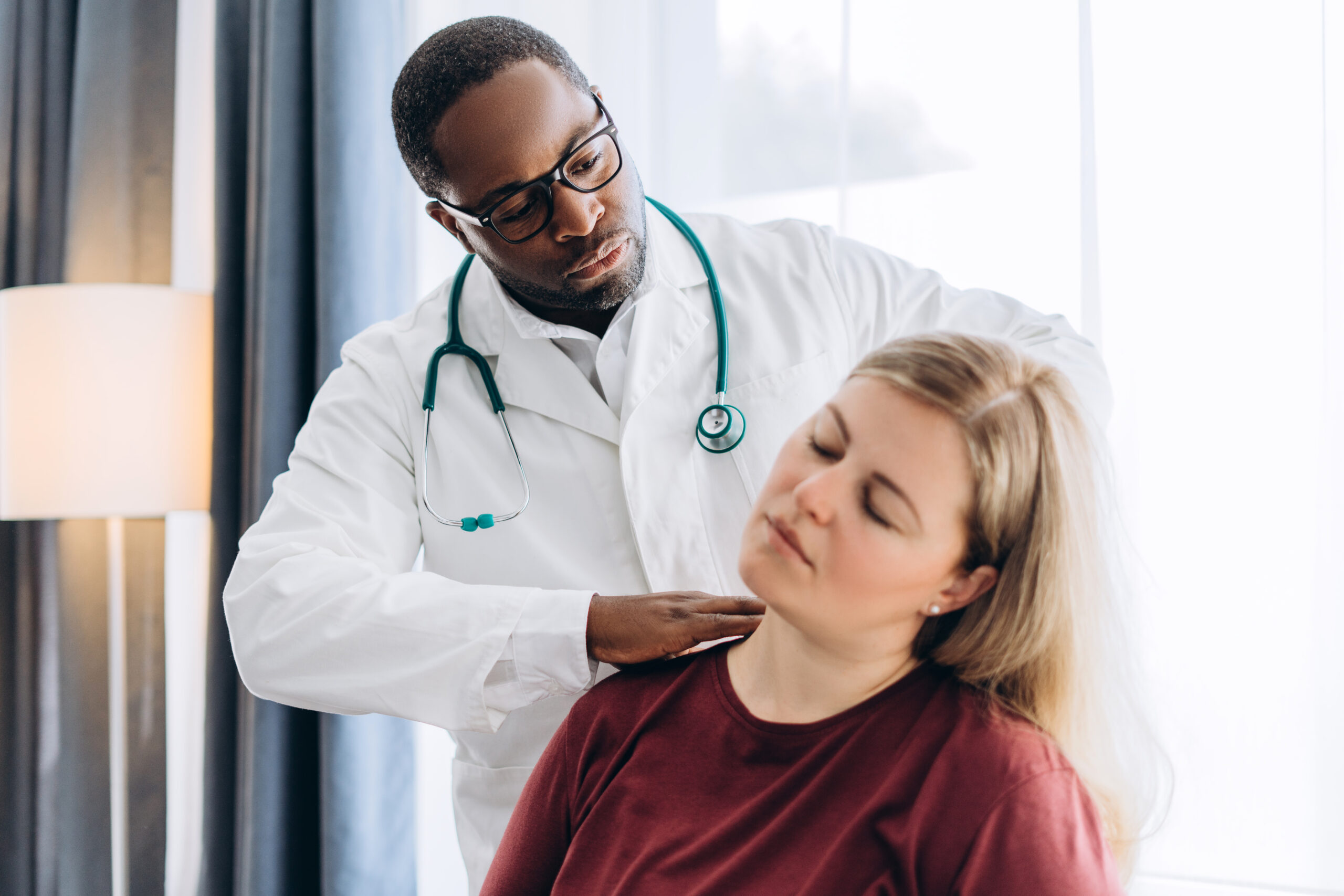 Physical therapist taking care of female patient with back pain at clinic.